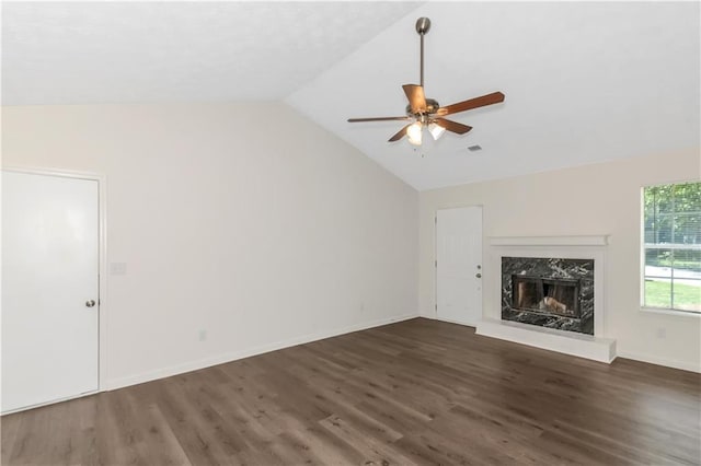 unfurnished living room featuring lofted ceiling, a ceiling fan, a high end fireplace, wood finished floors, and baseboards