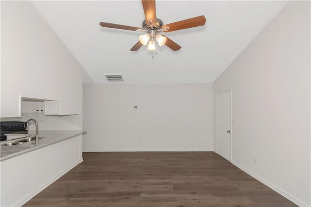 interior space featuring ceiling fan, visible vents, vaulted ceiling, and wood finished floors