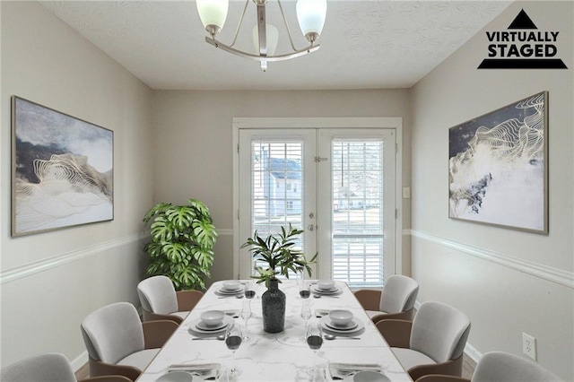 dining room with an inviting chandelier and a textured ceiling