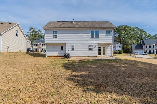 back of house featuring a patio, french doors, and a lawn