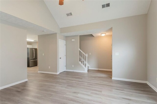 kitchen with light wood-type flooring, a sink, stainless steel appliances, white cabinets, and light countertops