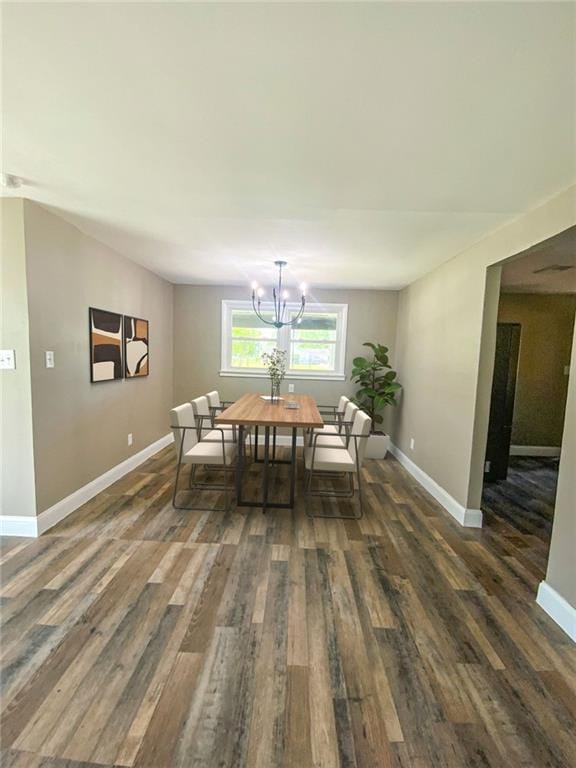 dining space with wood finished floors, an inviting chandelier, and baseboards