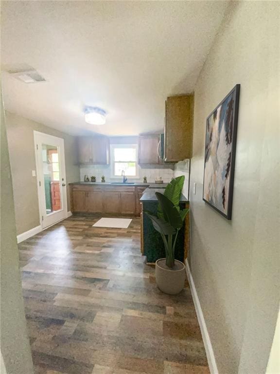 kitchen with dark wood finished floors, visible vents, stainless steel microwave, dark countertops, and baseboards