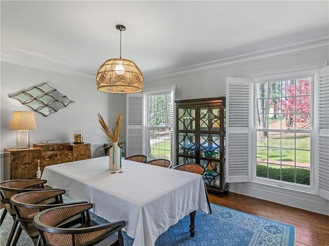 dining space with crown molding and dark wood-type flooring