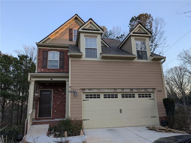 view of front of house with a garage, brick siding, roof with shingles, and concrete driveway