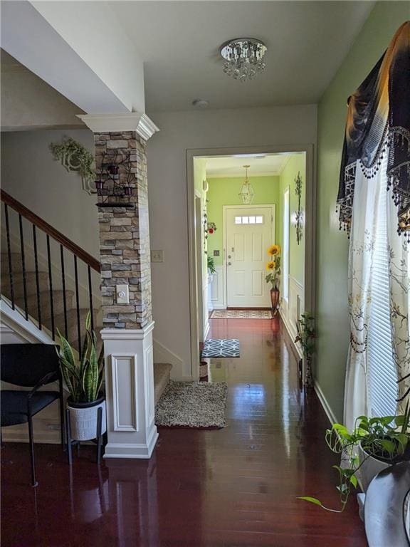 foyer entrance featuring dark hardwood / wood-style flooring and decorative columns