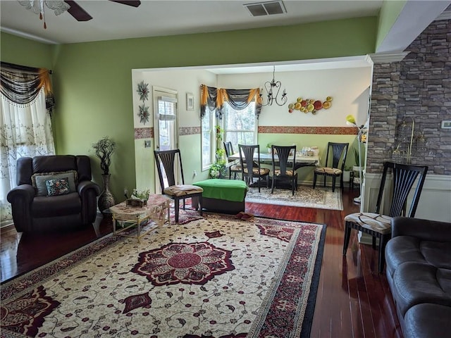 living room featuring ceiling fan with notable chandelier and wood-type flooring