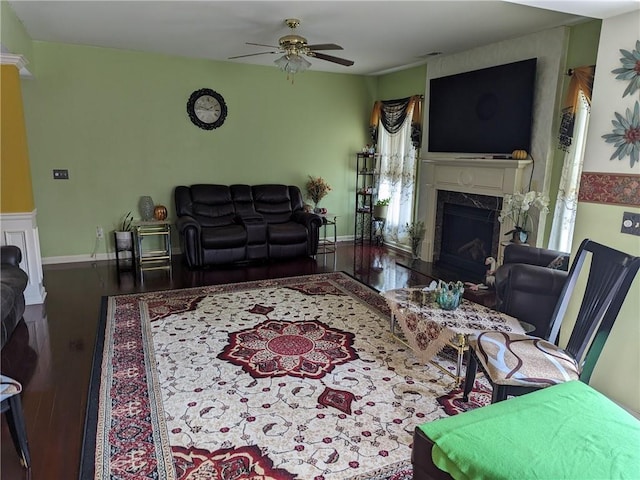 living room with ceiling fan, a high end fireplace, and hardwood / wood-style flooring