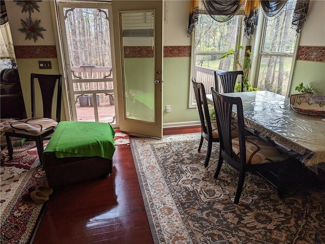 dining area featuring a healthy amount of sunlight and dark hardwood / wood-style floors