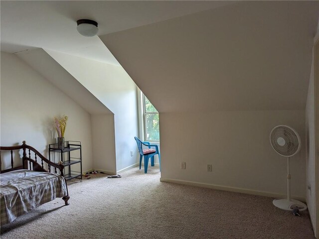 bedroom featuring ceiling fan, vaulted ceiling, and carpet flooring