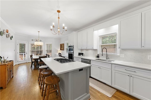 4250 Green Ridge Dr NE, Marietta, GA 30062 - kitchen with a chandelier, a kitchen breakfast bar, appliances with stainless steel finishes, a kitchen island, and ornamental molding