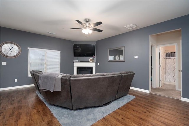 living room with ceiling fan and dark hardwood / wood-style flooring