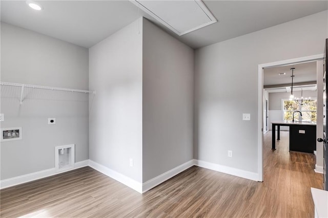 laundry area with hardwood / wood-style flooring, hookup for a washing machine, sink, and hookup for an electric dryer