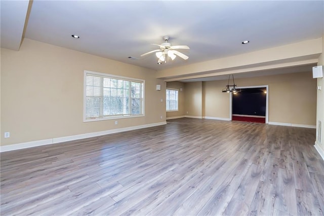 interior space featuring ceiling fan with notable chandelier and light wood-type flooring