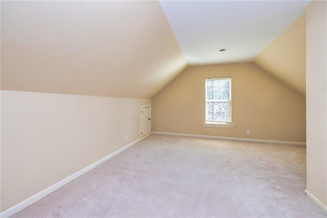 bonus room featuring lofted ceiling and light carpet