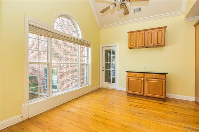 unfurnished dining area with high vaulted ceiling, ceiling fan, crown molding, and light hardwood / wood-style flooring