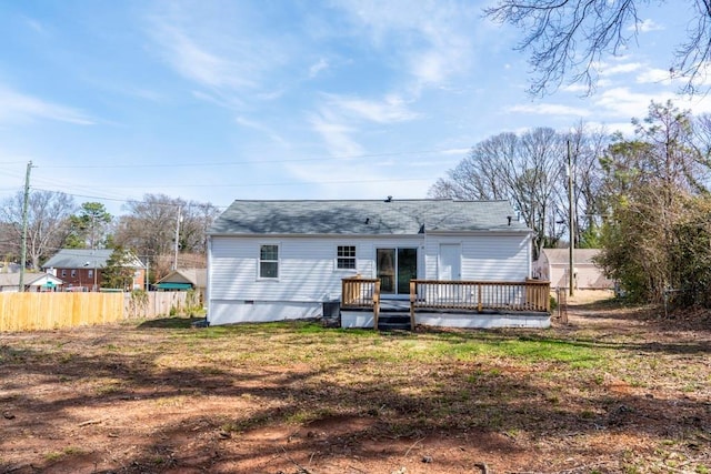 rear view of property with crawl space, a wooden deck, and fence