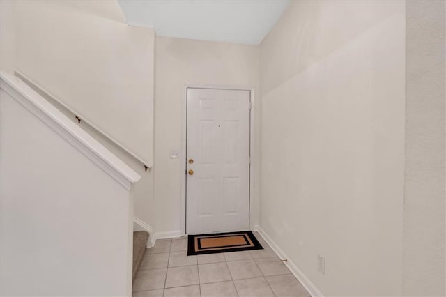 doorway to outside with light tile patterned flooring, baseboards, and stairs