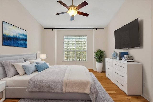 bedroom with light wood-type flooring, ceiling fan, and vaulted ceiling