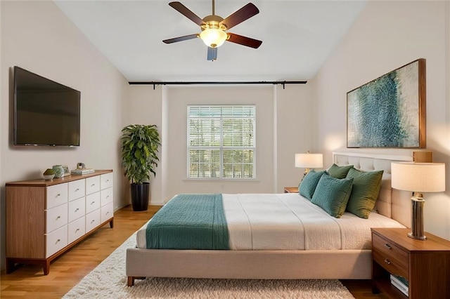 bedroom with vaulted ceiling, wood finished floors, and a ceiling fan