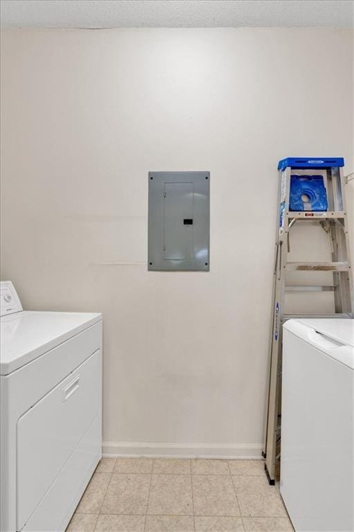 laundry area featuring laundry area, washing machine and clothes dryer, electric panel, and baseboards