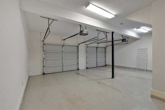 garage featuring a garage door opener and baseboards