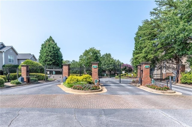 view of street featuring curbs, a gated entry, and a gate