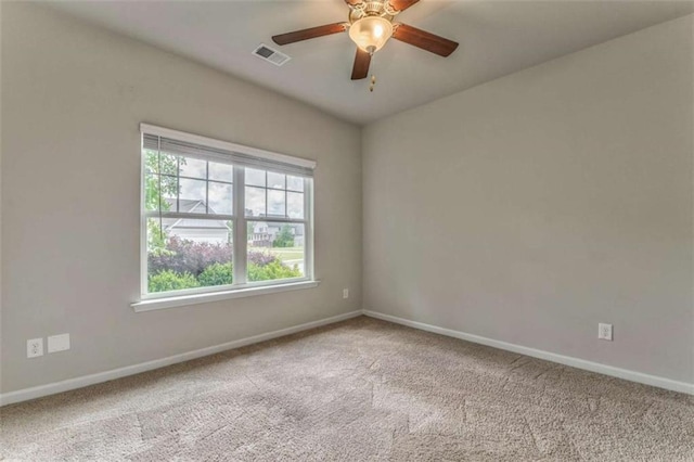 carpeted spare room featuring baseboards and a ceiling fan