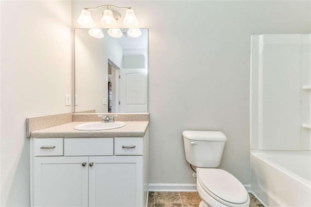 bathroom with toilet, vanity, and baseboards