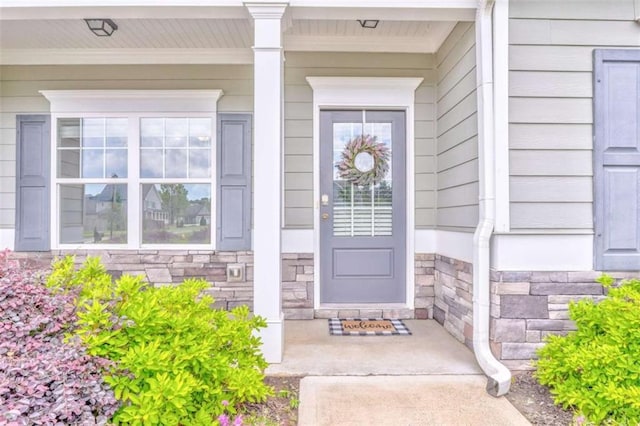 property entrance with stone siding and a porch