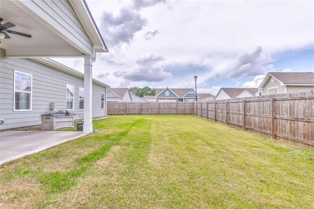 view of yard featuring ceiling fan and a patio
