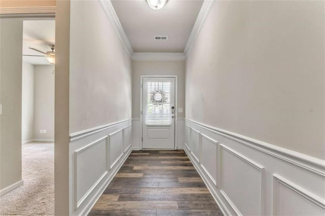 doorway featuring ornamental molding, a wainscoted wall, ceiling fan, and a decorative wall