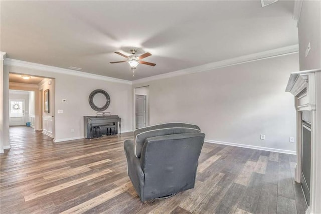 unfurnished living room featuring a fireplace, ceiling fan, wood finished floors, crown molding, and baseboards
