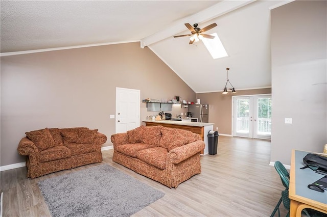 living room featuring lofted ceiling with skylight, french doors, ceiling fan, and light wood-type flooring