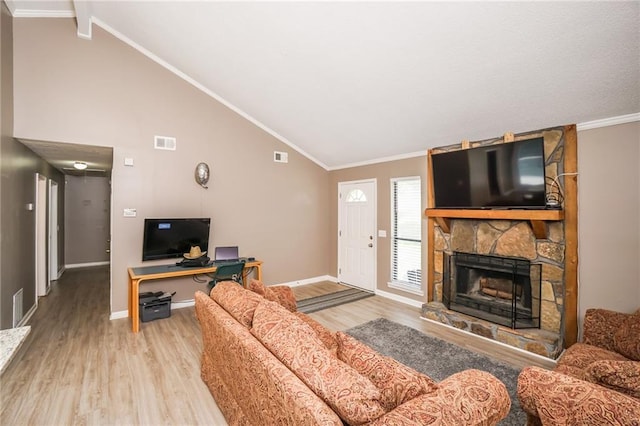 living room featuring vaulted ceiling, a stone fireplace, ornamental molding, and light hardwood / wood-style flooring