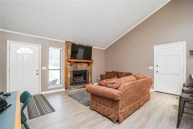 living room featuring hardwood / wood-style floors, lofted ceiling, a stone fireplace, and crown molding