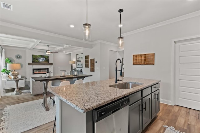 141 Wingate Dr, Auburn, GA 30680 - kitchen with stainless steel dishwasher, light wood-style flooring, a breakfast bar area, a kitchen island with sink, and crown molding