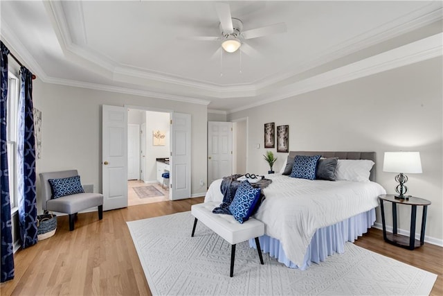 bedroom with ceiling fan, ornamental molding, a raised ceiling, and hardwood / wood-style floors