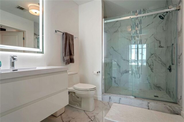 bathroom featuring vanity, a shower with shower door, and toilet