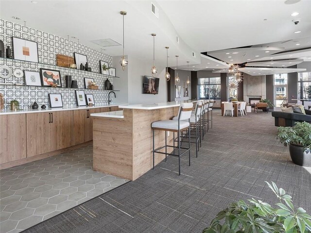 bar featuring dark carpet and hanging light fixtures