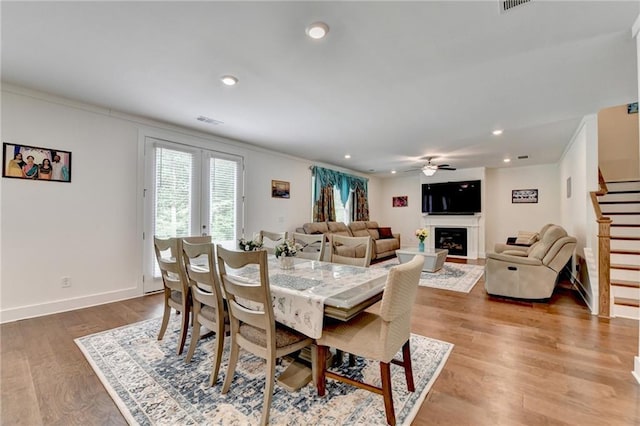 8125 Beryl Overlook, Gainesville, GA 30506 - dining space featuring wood finished floors, stairs, ceiling fan, visible vents, and crown molding