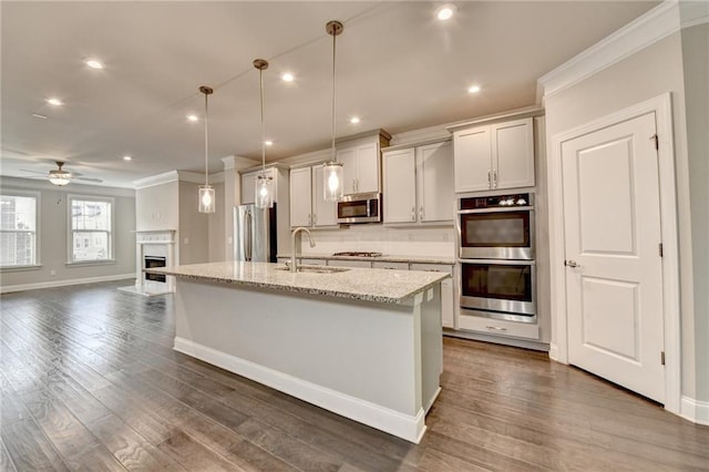 4232 Perimeter Park E Unit 110, Atlanta, GA 30341 - kitchen with stainless steel appliances, ornamental molding, ceiling fan, an island with sink, and dark wood-style floors