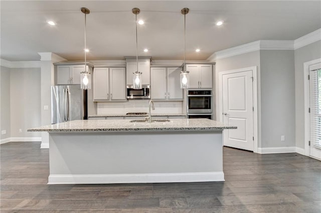 4232 Perimeter Park E Unit 110, Atlanta, GA 30341 - kitchen featuring stainless steel appliances, ornamental molding, an island with sink, dark wood finished floors, and light stone counters