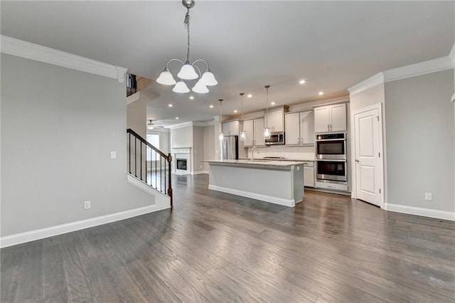 4232 Perimeter Park E Unit 110, Atlanta, GA 30341 - kitchen featuring appliances with stainless steel finishes, ornamental molding, open floor plan, a kitchen island with sink, and light countertops