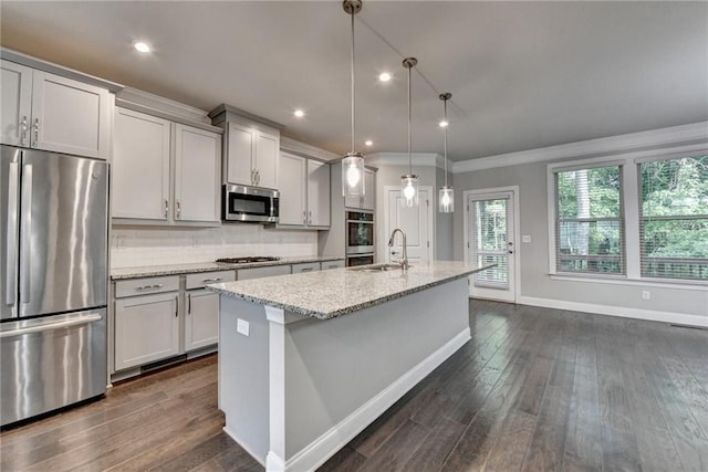 4232 Perimeter Park E Unit 110, Atlanta, GA 30341 - kitchen with appliances with stainless steel finishes, an island with sink, crown molding, dark wood finished floors, and light stone countertops