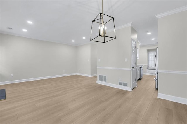 unfurnished dining area with ornamental molding, light wood-type flooring, and an inviting chandelier