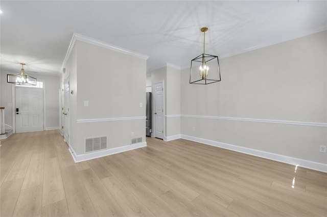 unfurnished dining area featuring light hardwood / wood-style floors, crown molding, and a notable chandelier