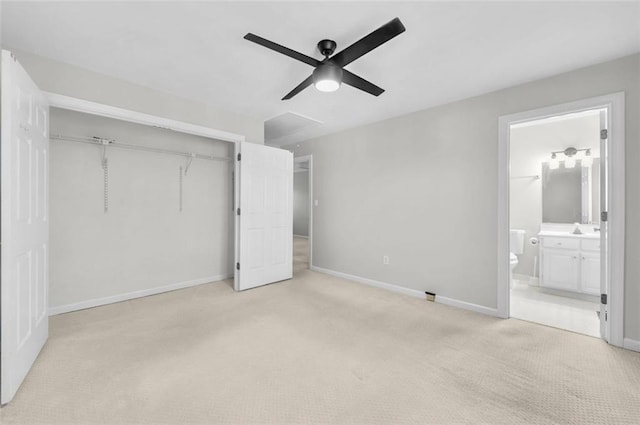 unfurnished bedroom featuring ensuite bath, sink, a closet, ceiling fan, and light carpet