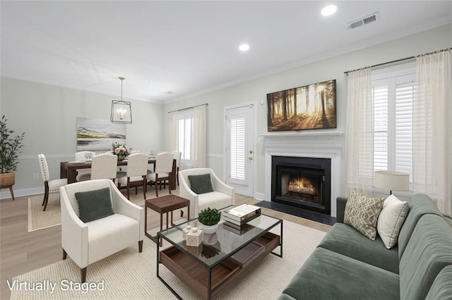 living room with light hardwood / wood-style floors and crown molding