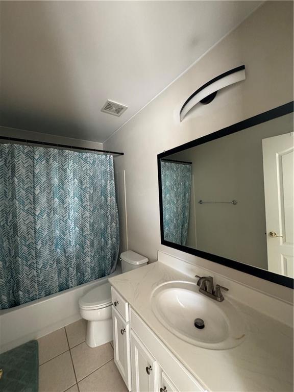 full bathroom with tile patterned flooring, vanity, toilet, visible vents, and shower / bath combo